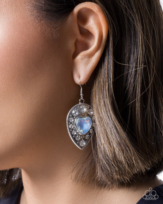 Earring with heart-shaped gem worn by a person
