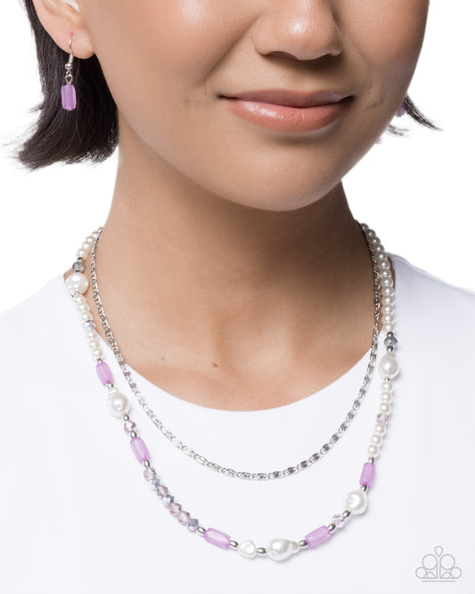 Necklace with purple and white beads worn by a model on a white background