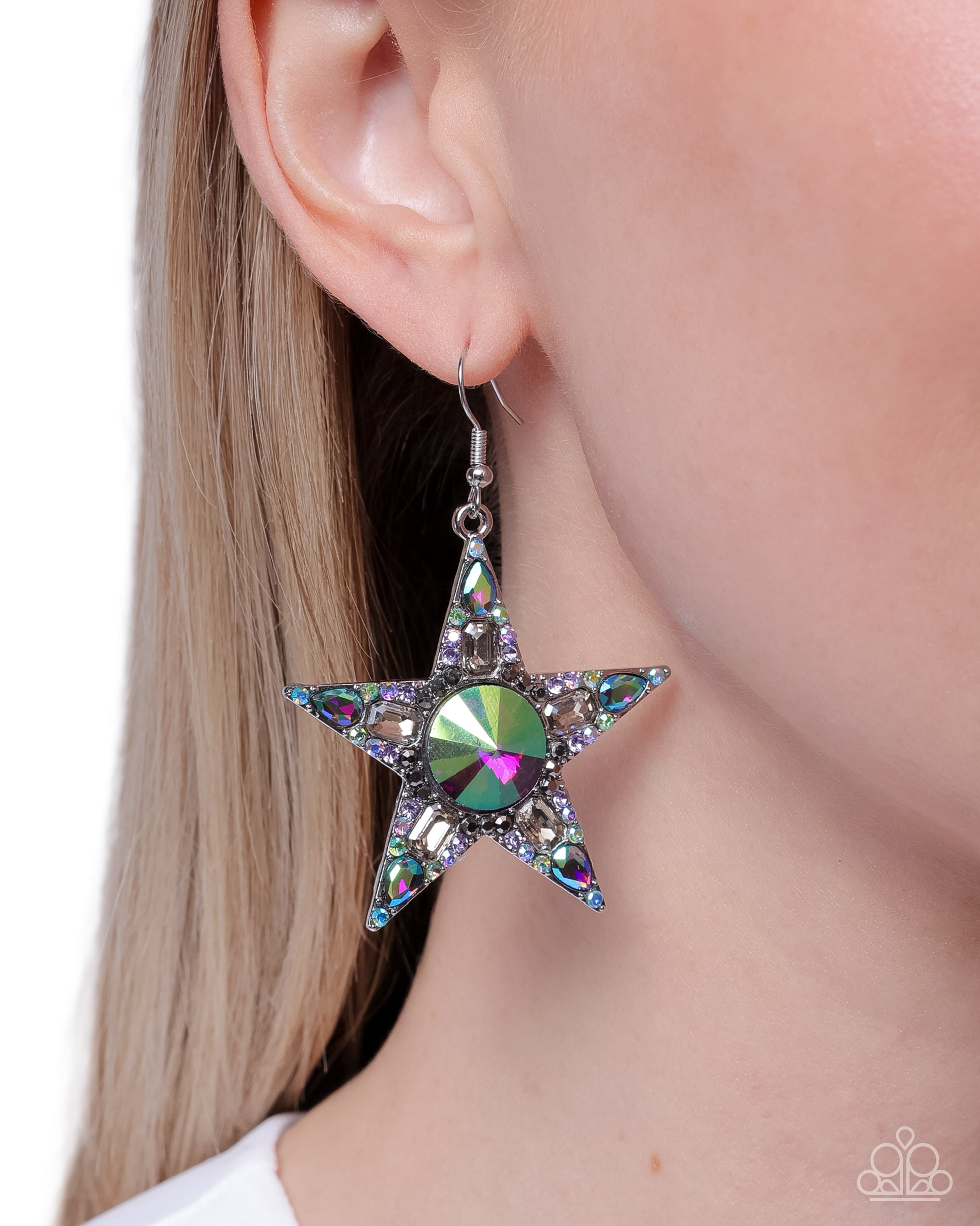 Star-shaped earring with a central gemstone worn by a person