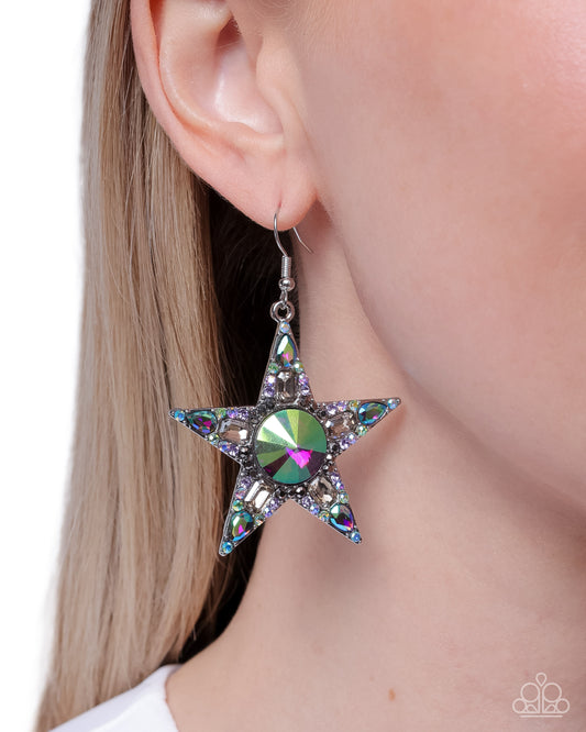 Star-shaped earring with a central gemstone worn by a person
