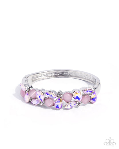 Silver ring with pink and purple gemstones on a white background