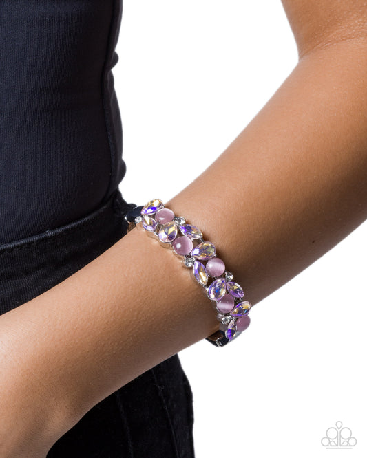 Purple beaded bracelet on a wrist with a white background