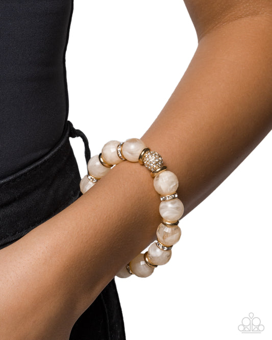 Pearl bracelet on a wrist with a black background