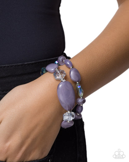 Purple beaded bracelet on a wrist with a white background