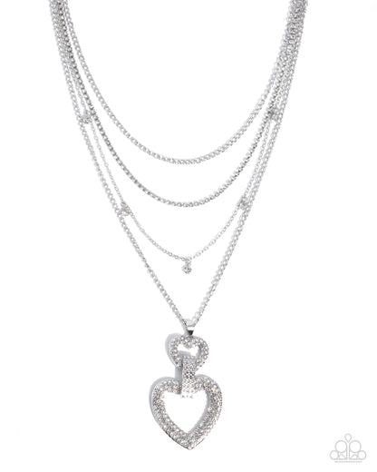 Layered silver necklaces with a heart pendant on a white background