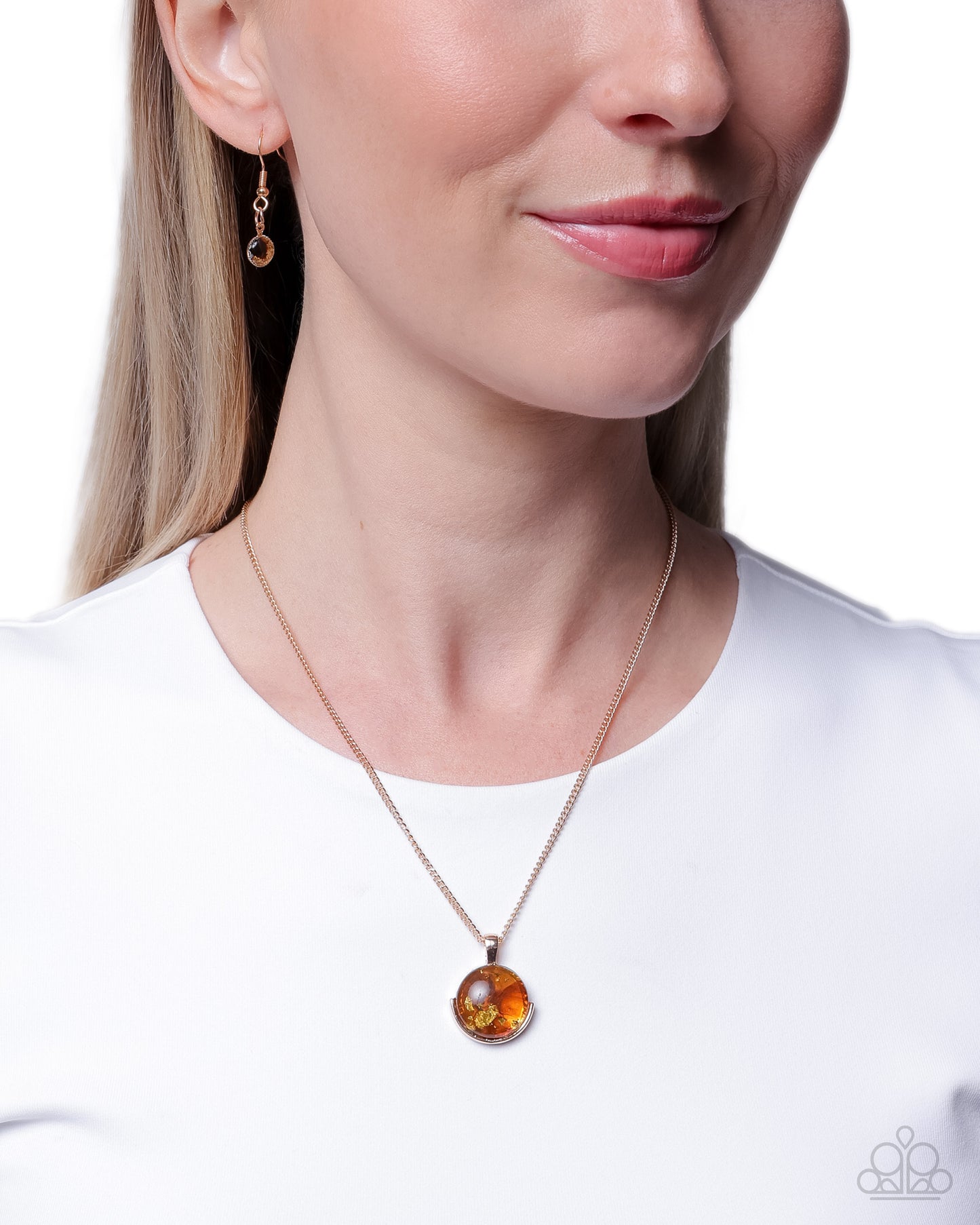 Close-up of a woman wearing a gold necklace with a round pendant on a white background