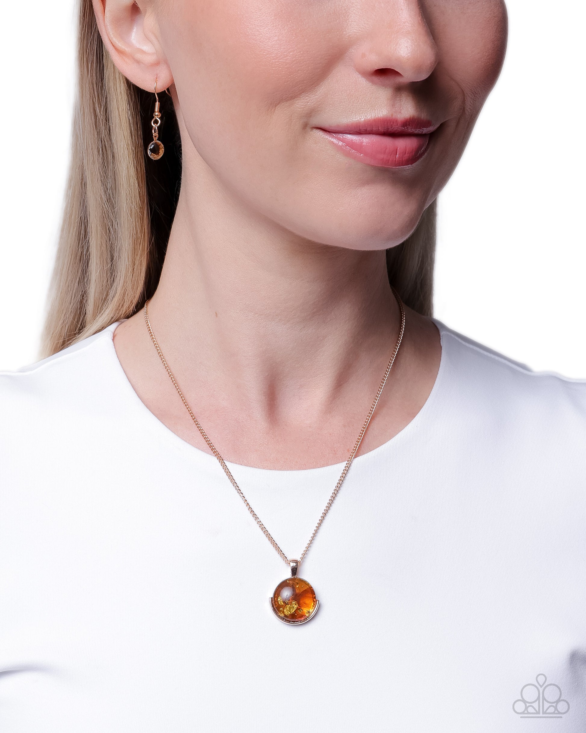 Close-up of a woman wearing a gold necklace with a round pendant on a white background