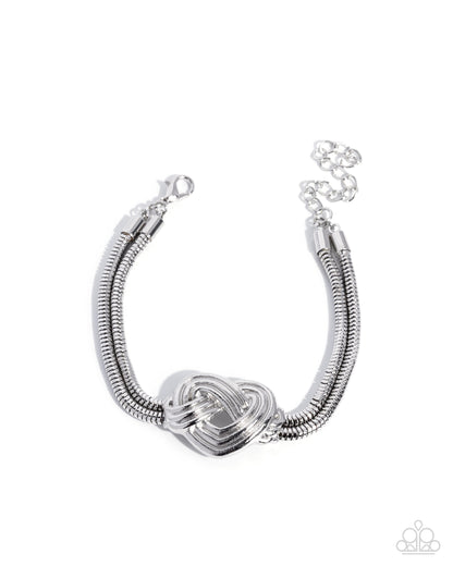 Silver bracelet with a heart-shaped clasp on a white background