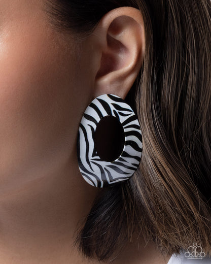 Earring with zebra pattern worn on an ear