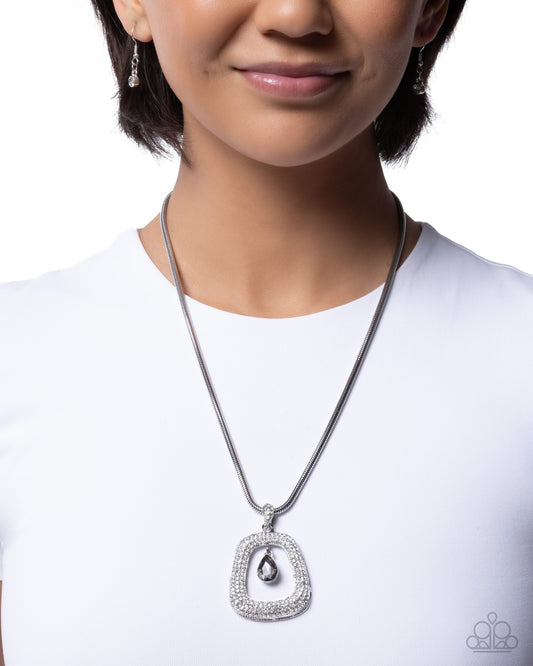 Person wearing a silver necklace with a teardrop pendant on a white background