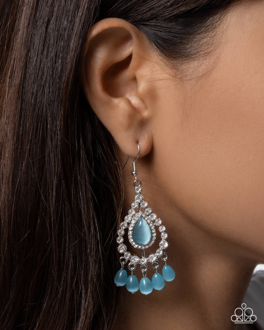 Close-up of an ear wearing a turquoise teardrop earring with dangling beads.