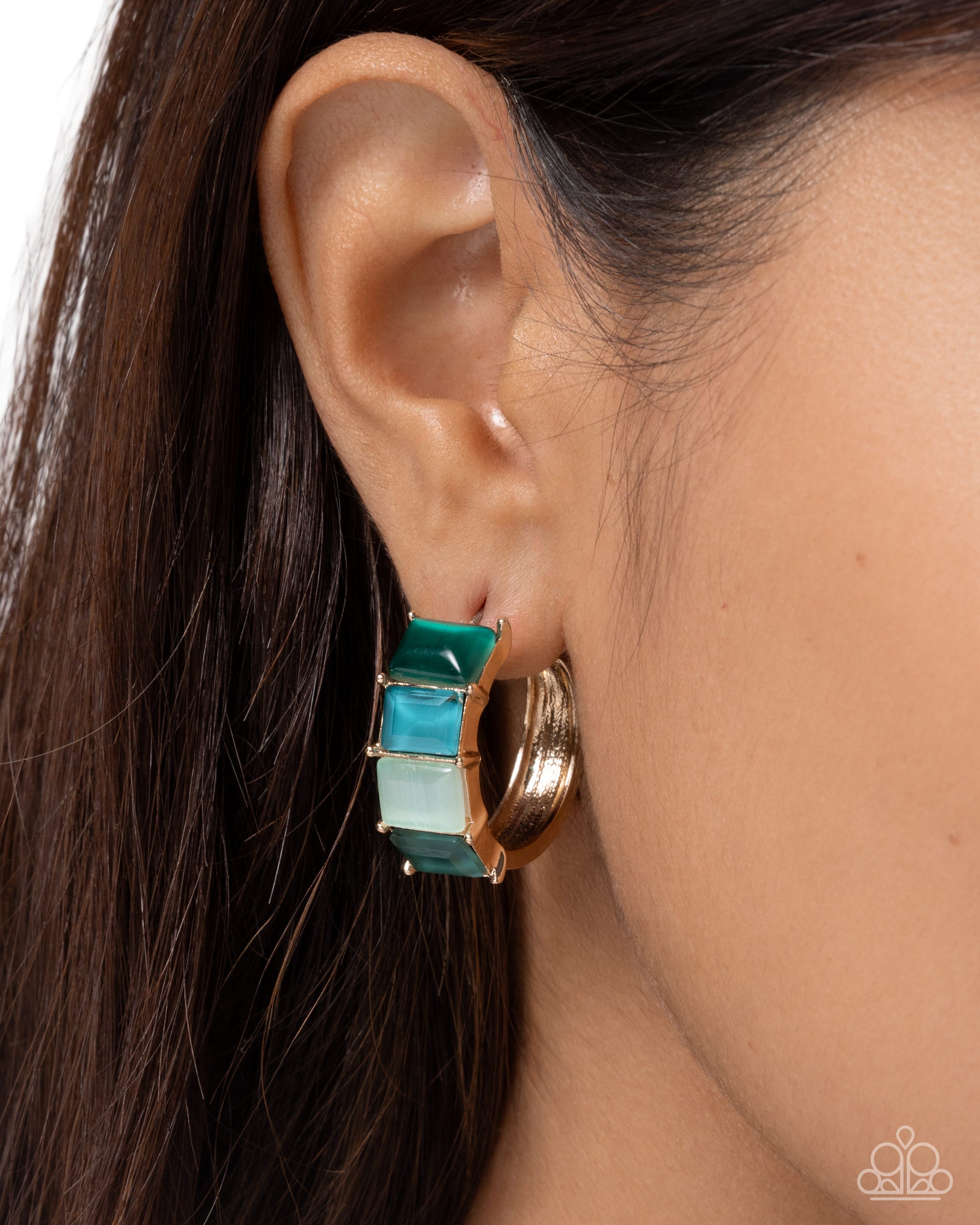 Close-up of an ear wearing a gold and turquoise earring