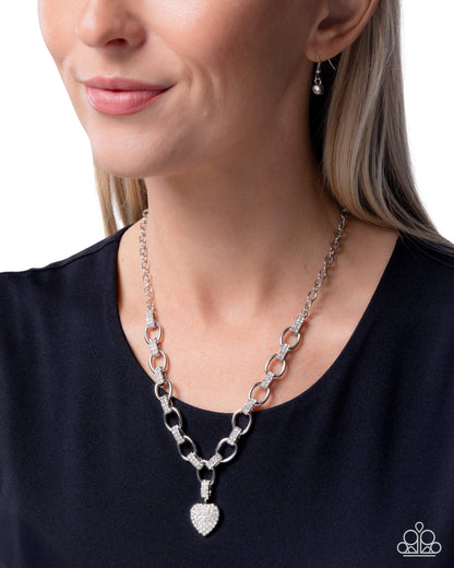 Silver chain necklace worn by a model on a white background