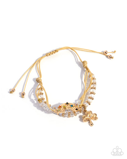 Gold bracelet with clover charms on a white background