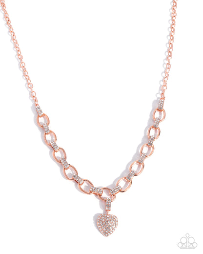 Rose gold chain necklace with a heart pendant on a white background