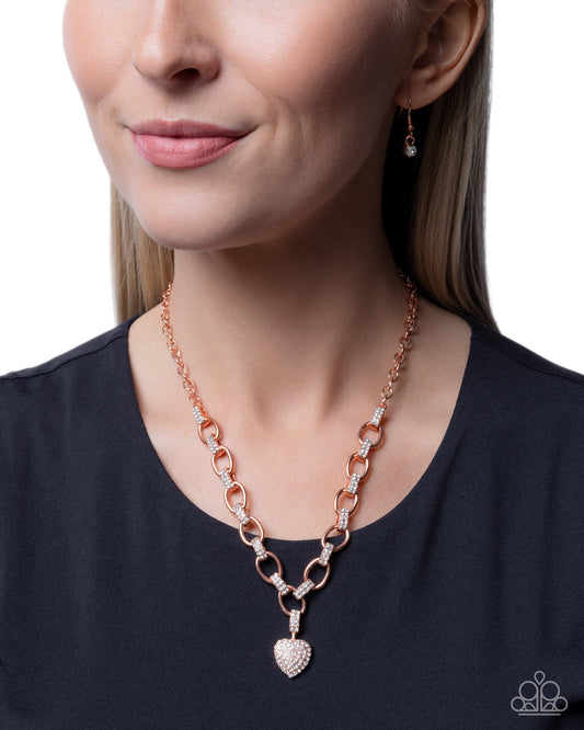 Rose gold chain necklace with heart pendant worn by a model on a white background