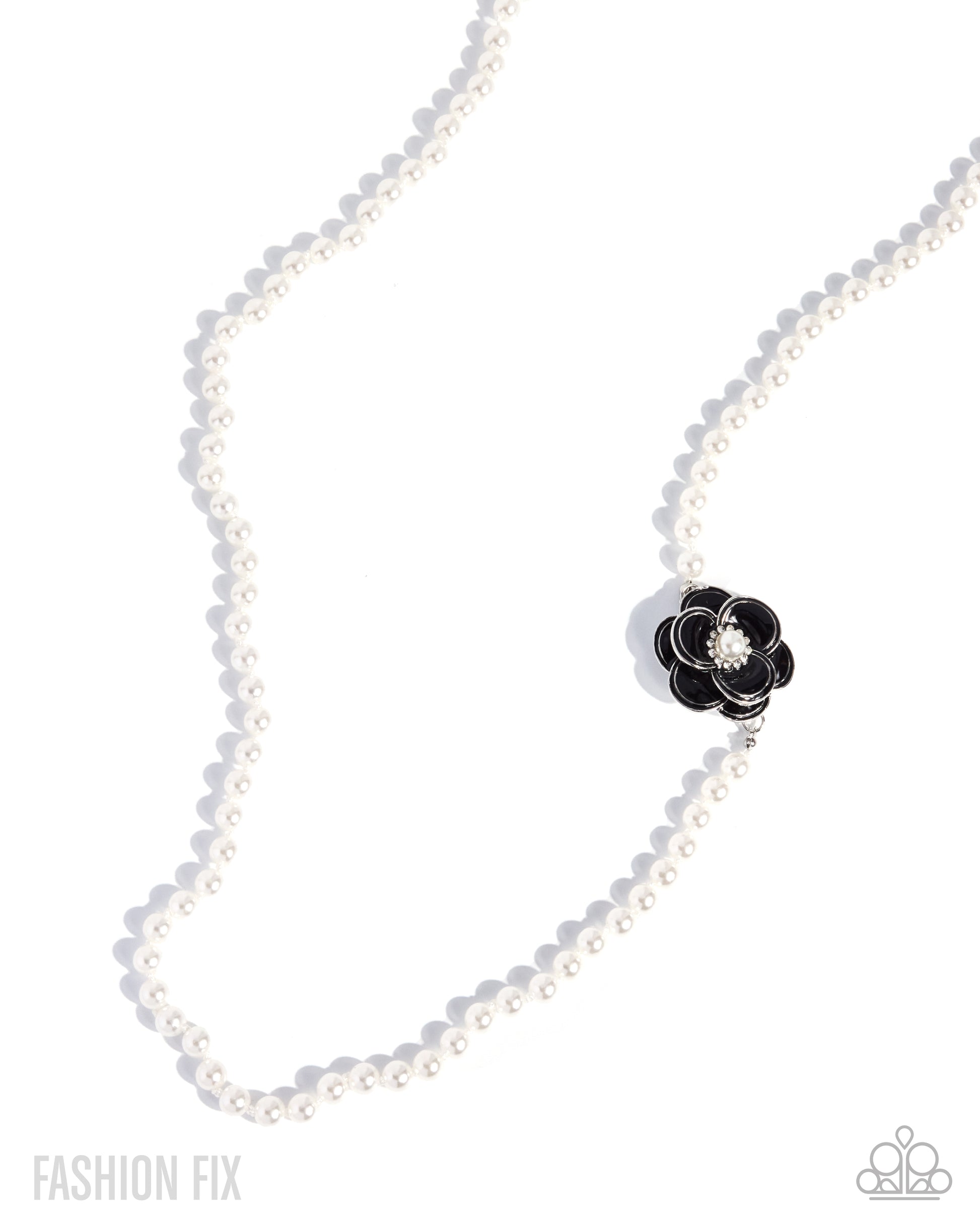 A white pearl necklace with a black flower-shaped charm featuring a clear crystal center, displayed on a clean white background with soft shadows.