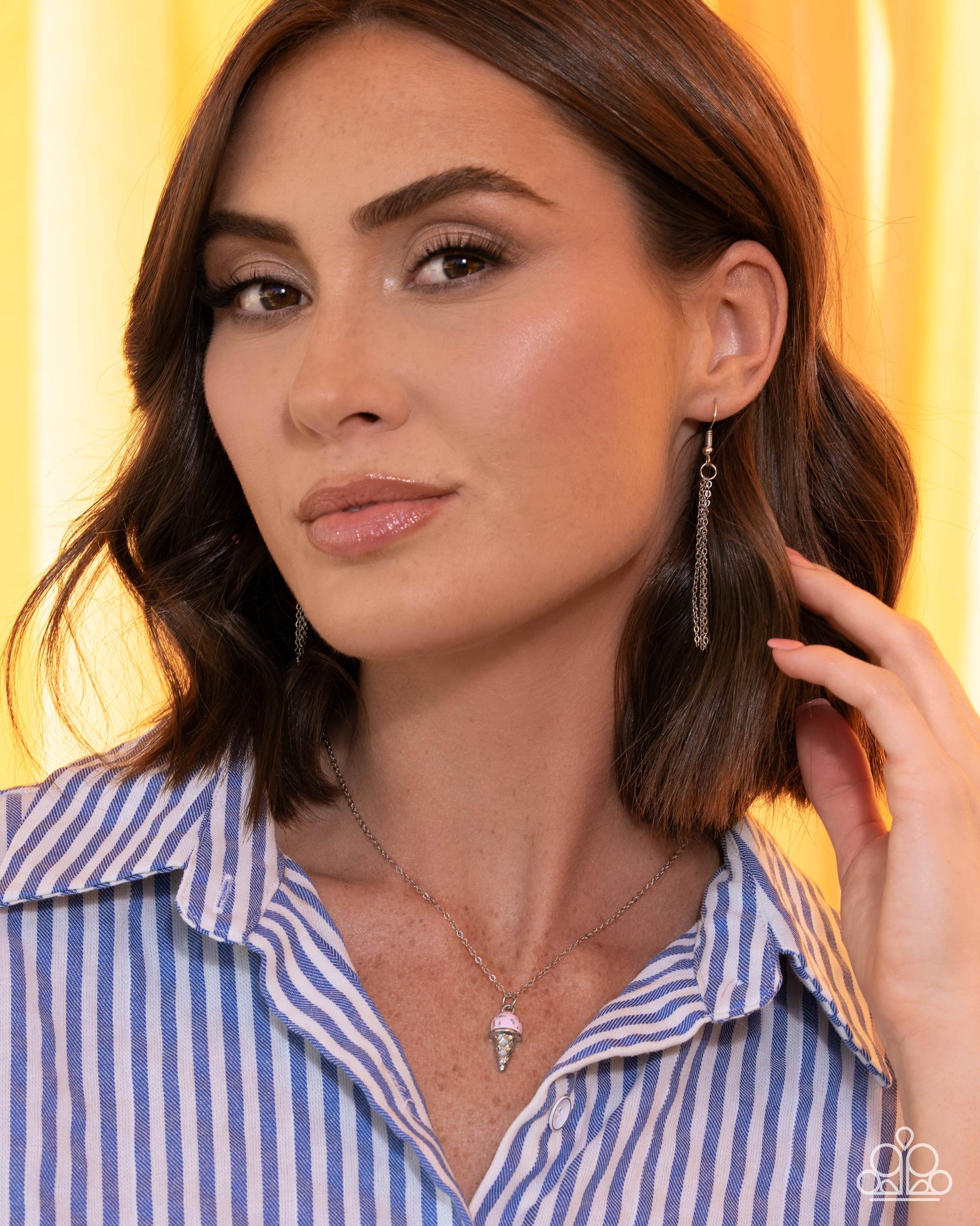 Woman wearing earrings with a yellow background