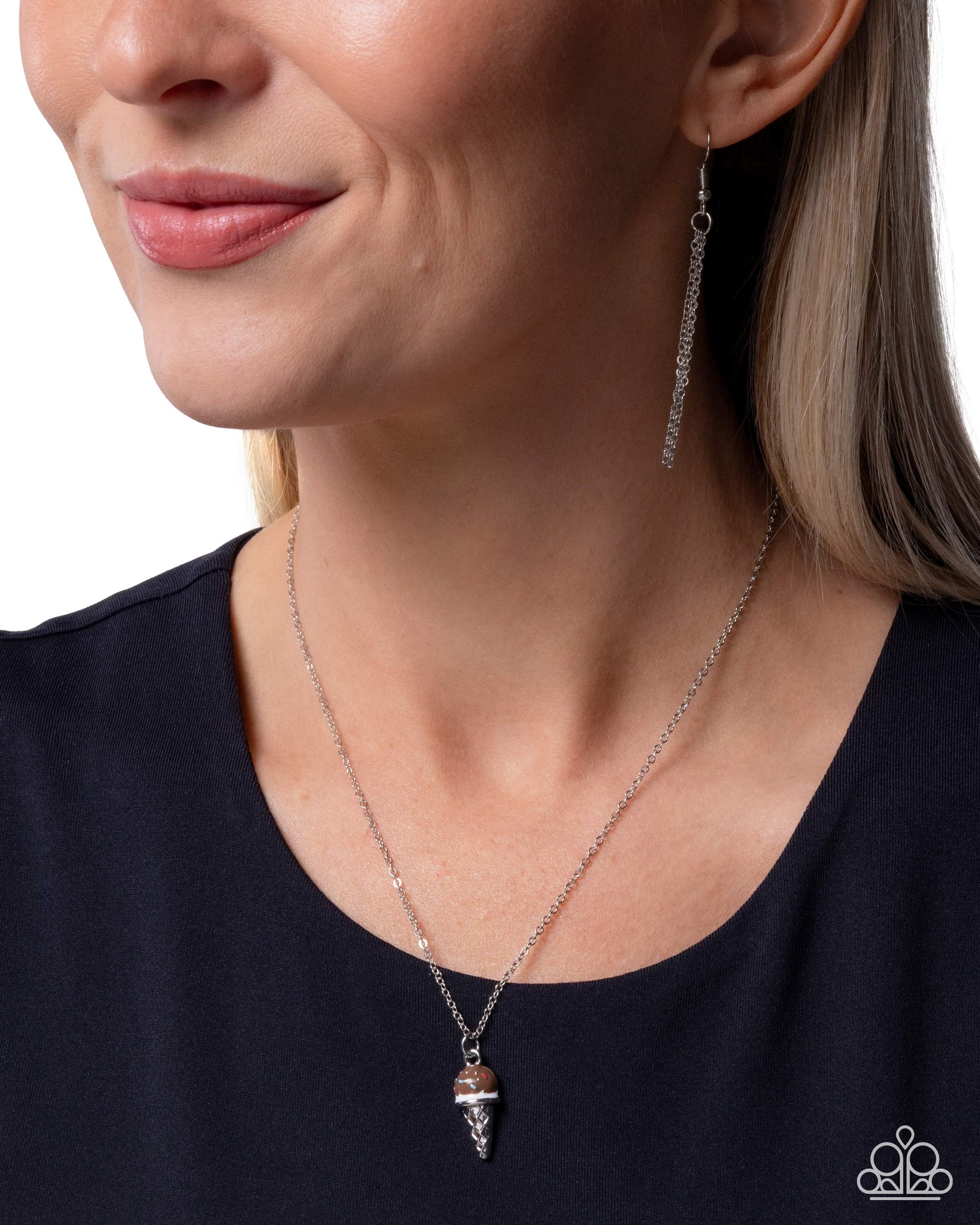 Close-up of a woman wearing a silver necklace and earring set against a white background