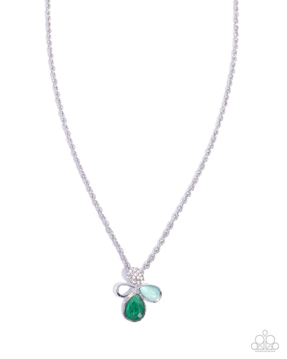 A silver-tone chain necklace featuring a bow-shaped pendant with a large teardrop green gemstone and two smaller light green gemstones, shown on a plain white background.