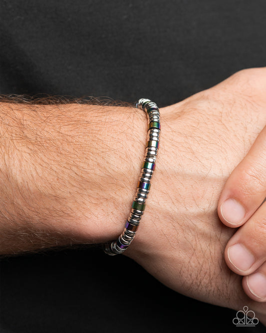 Multicolored beaded bracelet on a wrist against a black background
