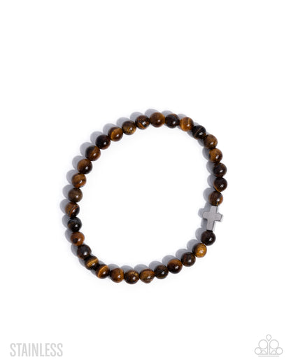 Bracelet with brown beads and a silver cross on a white background