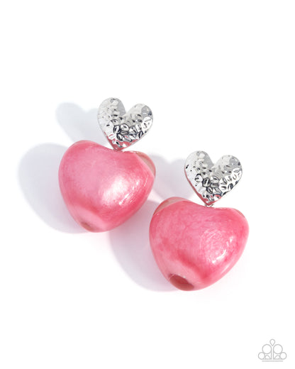 Pink heart-shaped earrings with silver accents on a white background