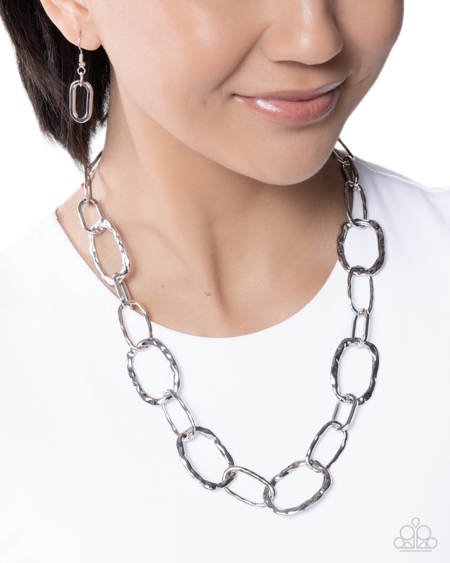 Person wearing a silver chain necklace on a white background