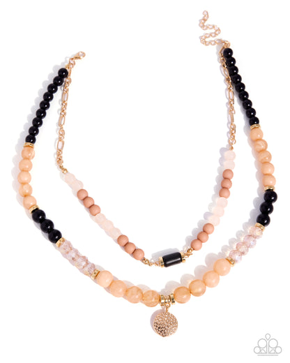 Two layered beaded necklaces with black, peach, and gold beads on a white background