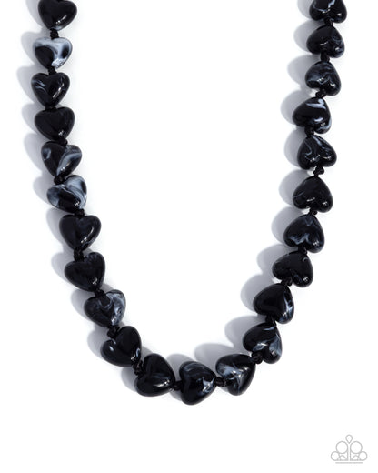 Necklace with black heart-shaped beads on a white background