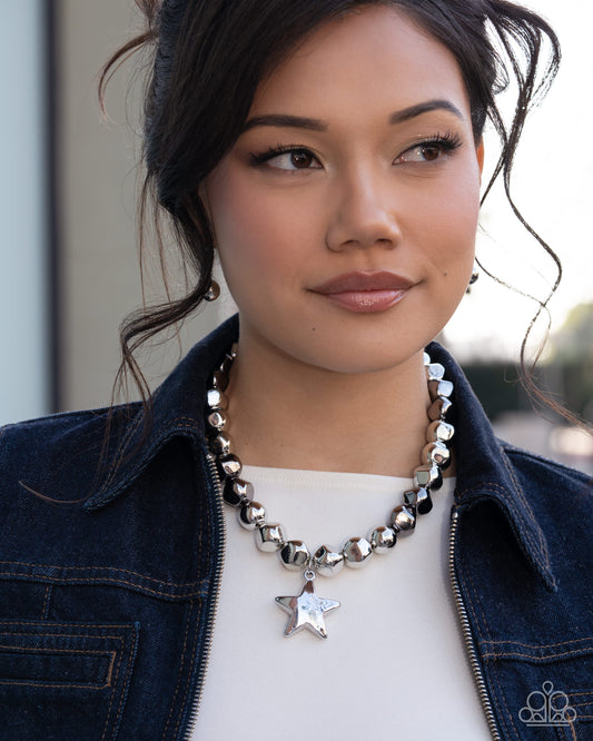 Woman wearing a star-shaped pendant necklace with a denim jacket