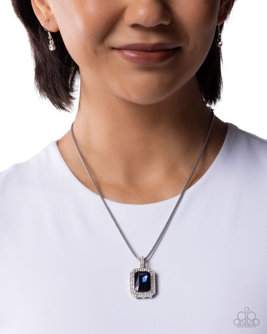 Woman wearing a silver necklace with a dark pendant on a white background