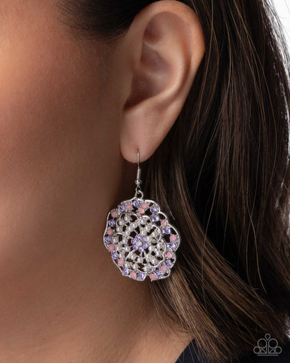Close-up of an ear wearing a colorful earring with a blurred background