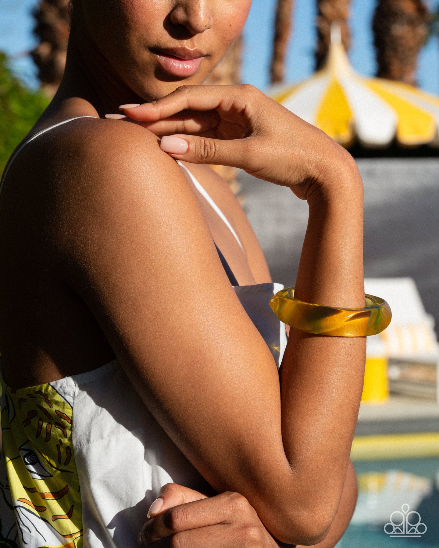 Person wearing a yellow bangle with a blurred background