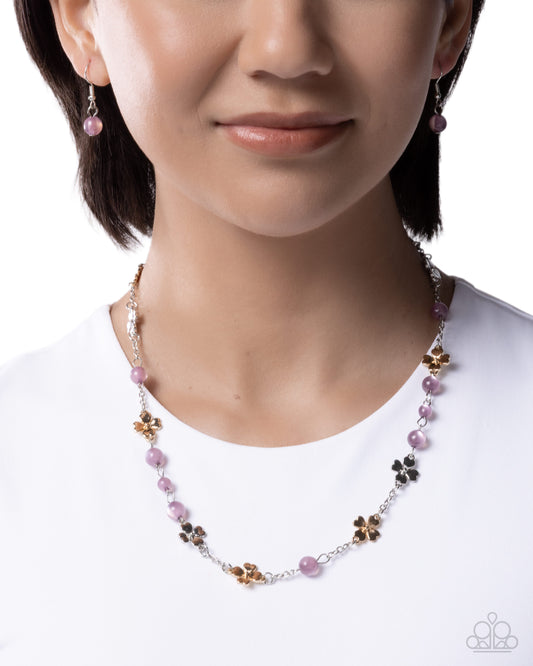 Necklace with pink and brown beads worn by a model on a white background
