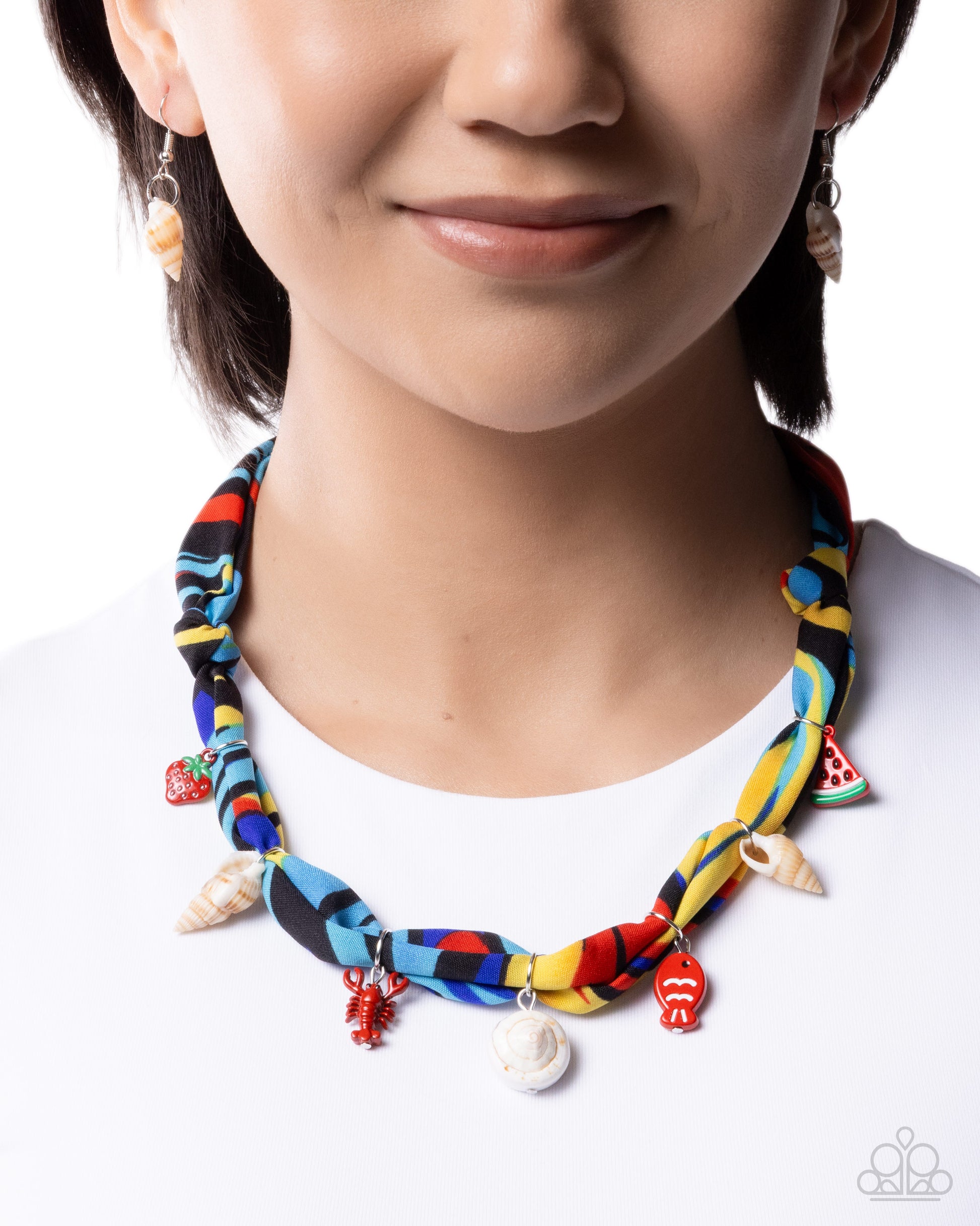 Person wearing a colorful braided necklace with various charms on a white background