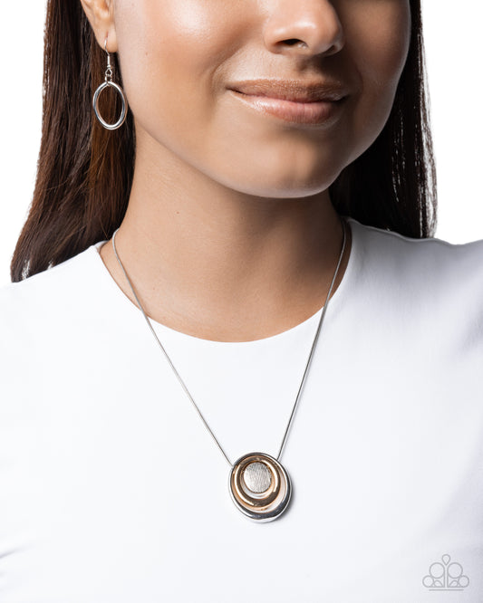Necklace with a circular pendant worn by a model on a white background