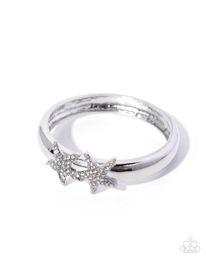 Silver ring with starfish design on a white background
