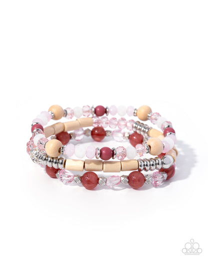 Set of three beaded bracelets with pink, red, and beige beads on a white background