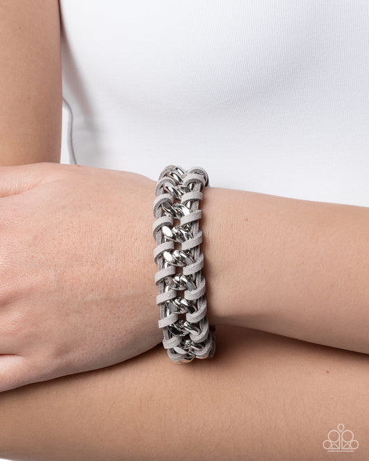 Silver chain bracelet on a wrist with a white background