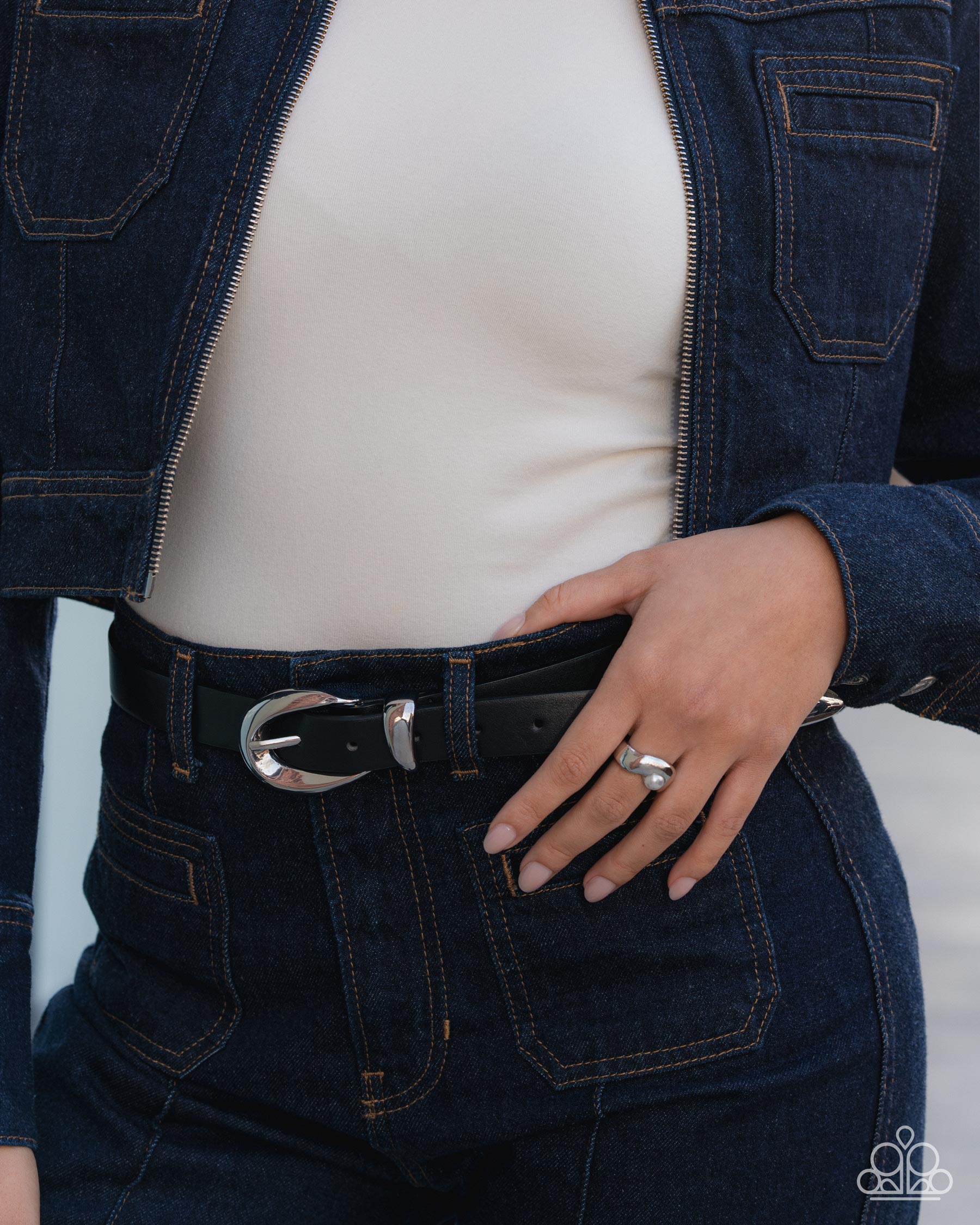 Person wearing a dark blue denim jacket and jeans with a white background