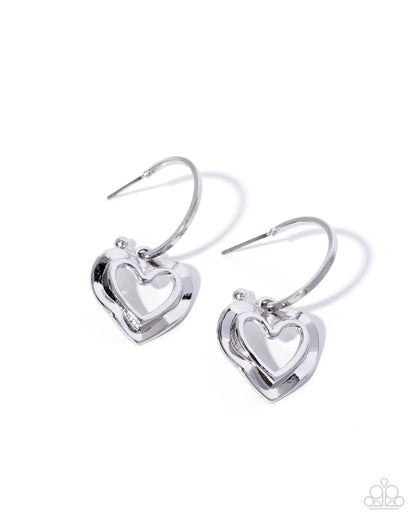 Pair of silver heart-shaped earrings on a white background