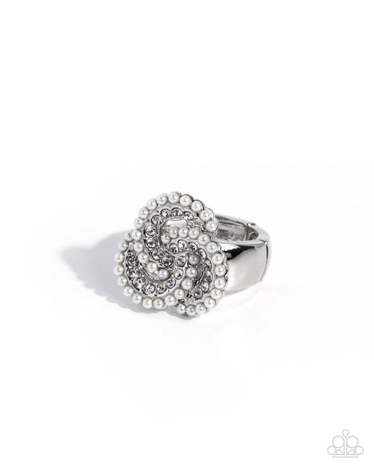 A silver-tone ring featuring a large, textured flower-shaped cluster embellished with clear rhinestones and white faux pearls, shown on a clean white background.