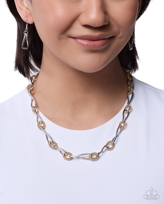 Person wearing a gold and silver chain necklace on a white background
