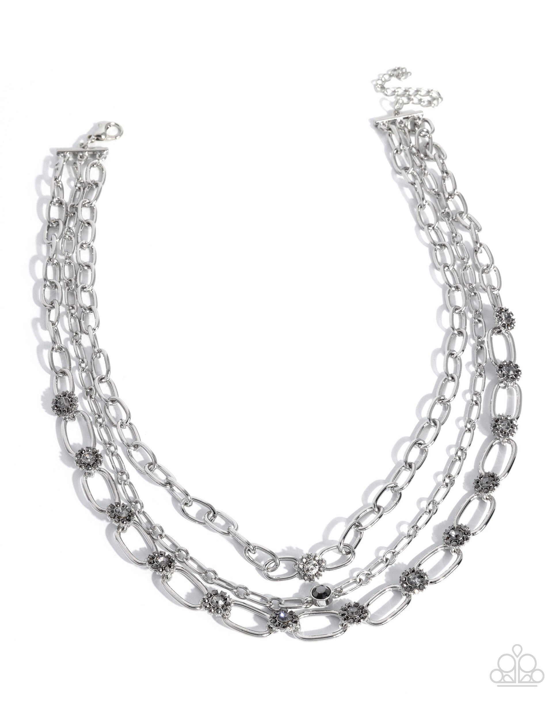 Multi-layered silver chain necklace with small embellishments on a white background