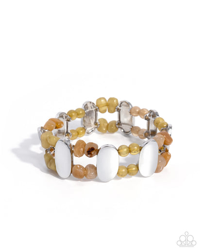 Multicolored beaded bracelet with white accents on a white background