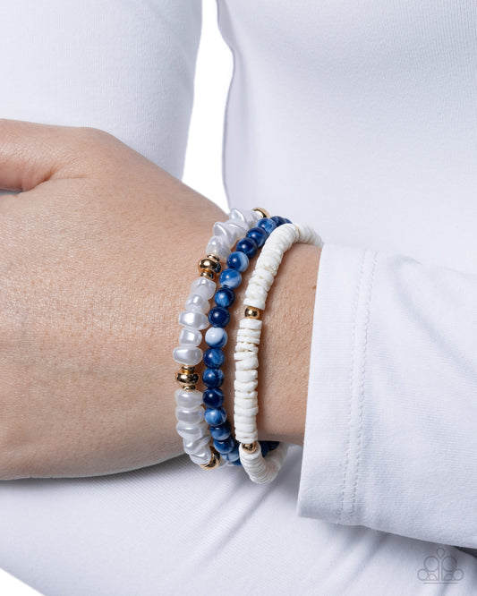 Close-up of a wrist wearing two beaded bracelets on a white background