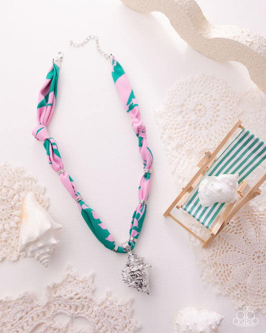 Necklace with pink and green pattern on a textured surface