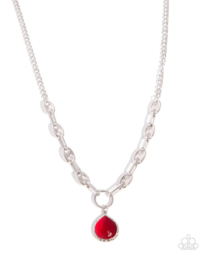 Silver chain necklace with a red pendant on a white background