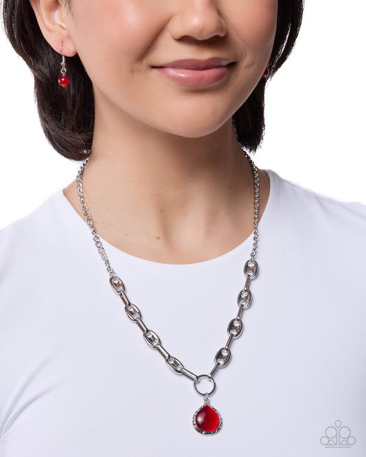 Woman wearing a silver chain necklace with red pendant on a white background